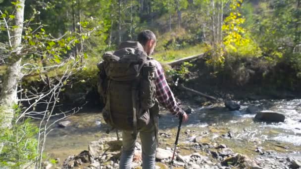 人与背包徒步旅行在山附近河 — 图库视频影像