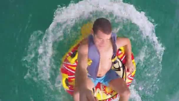Muž sedící nafukovací prstenec vlečné lodi do vody a nahrávání sebe s Go Pro kameru — Stock video