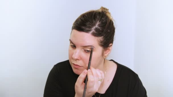 Mooie jonge vrouw toepassing van make-up. — Stockvideo