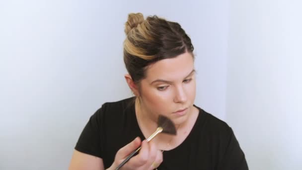 Beautiful young woman applying makeup. — Stock Video
