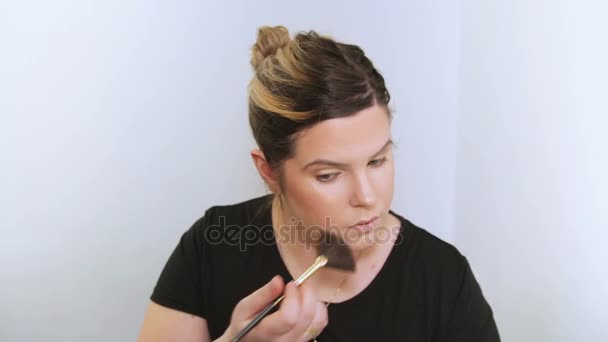 Belle jeune femme appliquant le maquillage .