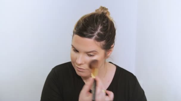 Belle jeune femme appliquant le maquillage .