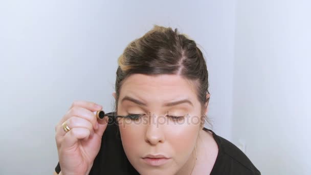 Vacker ung kvinna tillämpa makeup. — Stockvideo