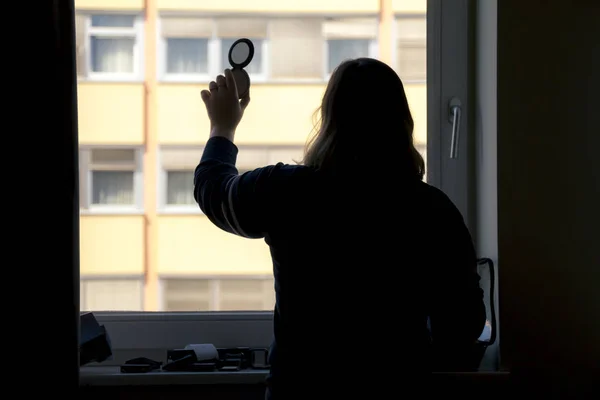 Vista posterior de la silueta de una mujer que se pone maquillaje delante de — Foto de Stock