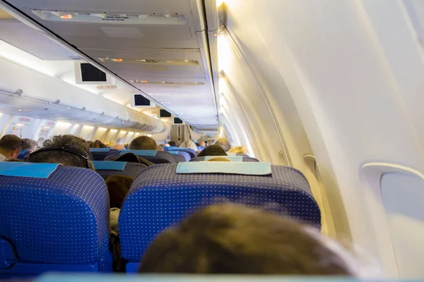 Interior del avión de pasajeros con personas en asientos — Foto de Stock