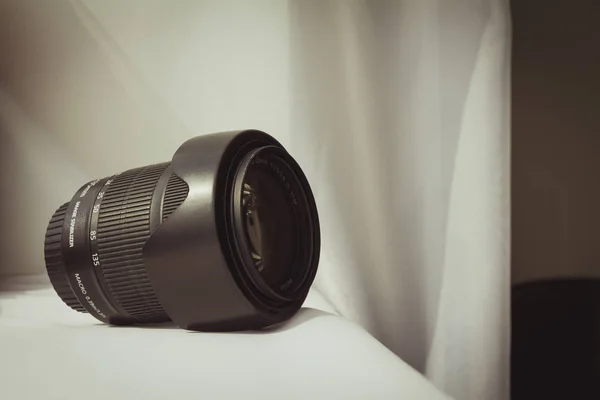 Lente zoom câmera preta em pano branco — Fotografia de Stock