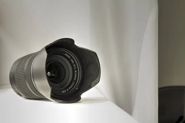 Zwarte camera zoomlens op witte doek — Stockfoto