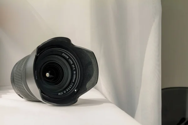 Zwarte camera zoomlens op witte doek — Stockfoto