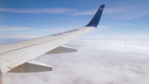 Крило літака на небі і над морем з хмарами — стокове відео