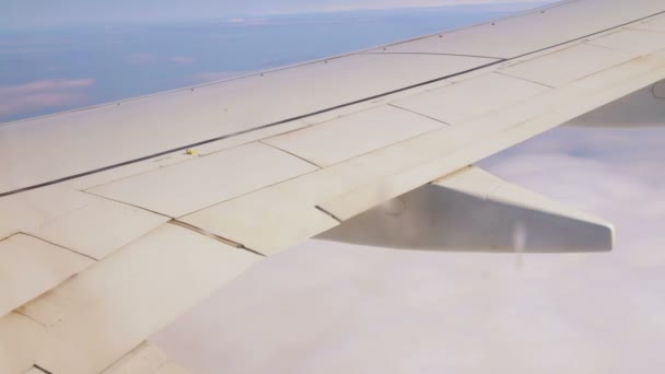 Vliegtuig vleugels in de lucht en over zee met wolken — Stockvideo