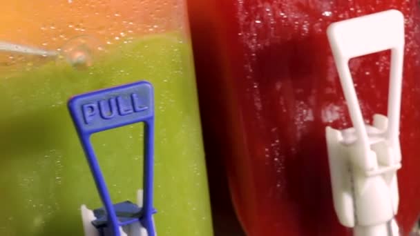 Três máquinas de suco úmido contatinando sabores de frutas frias bebidas de gelo raspadas — Vídeo de Stock