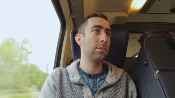 Jonge man op een trein reizen en praten met iemand — Stockvideo