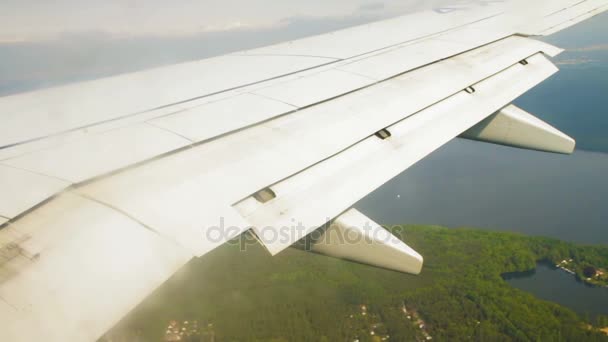 Flygplansvinge under landning med klaffar ner på himlen över mark — Stockvideo