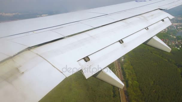 Ala de avión durante el aterrizaje con aletas en el cielo sobre tierra — Vídeos de Stock