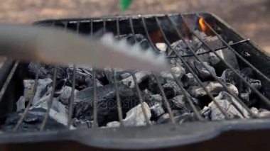Adam mangal barbekü açık havada için hazırlar.
