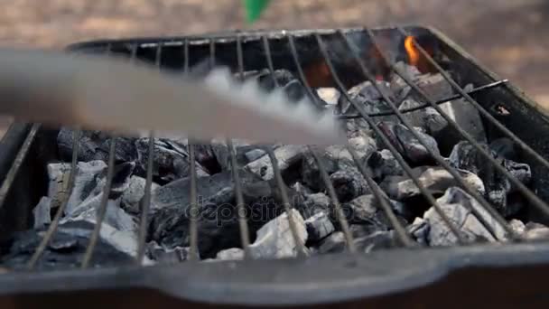 Człowiek przygotowuje grill grilla na świeżym powietrzu — Wideo stockowe