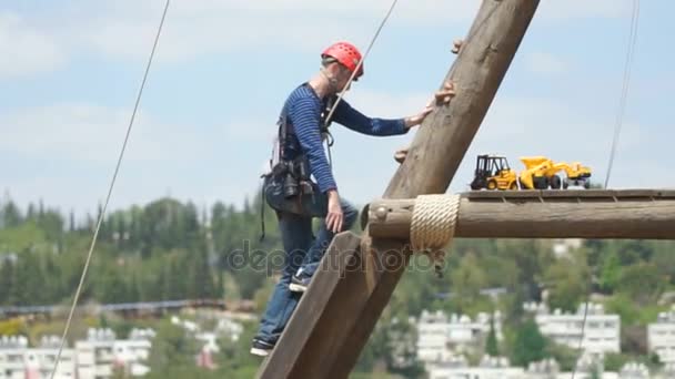 Экстремальный профессиональный видеограф во время съёмок на альпинистской башне, работающий в экстремальных условиях — стоковое видео