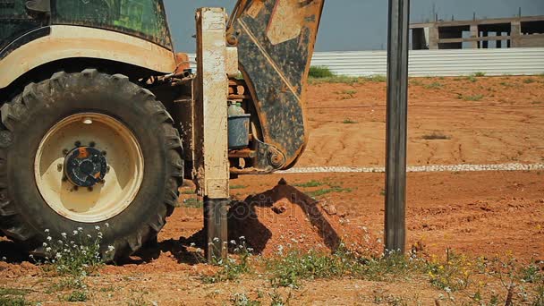 Gráfico do tractor com um dispositivo de perfuração num estaleiro de construção — Vídeo de Stock