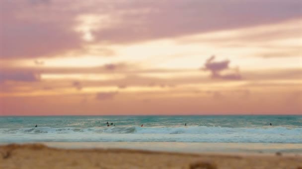 Cinemagraph van groep van surfers, surfen in de Middellandse Zee bij zonsondergang in Palmahim strand in Israël — Stockvideo
