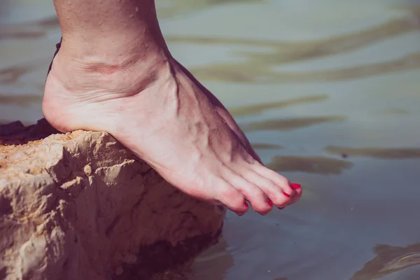 在河边的岩石边上, 白种人妇女赤脚滴水 — 图库照片