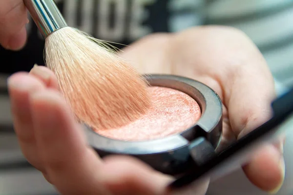 Primo piano delle mani della donna che tengono il pennello di trucco e la scatola di arrossamento — Foto Stock