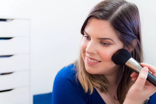 Mujer aplicando maquillaje en su dormitorio — Foto de Stock