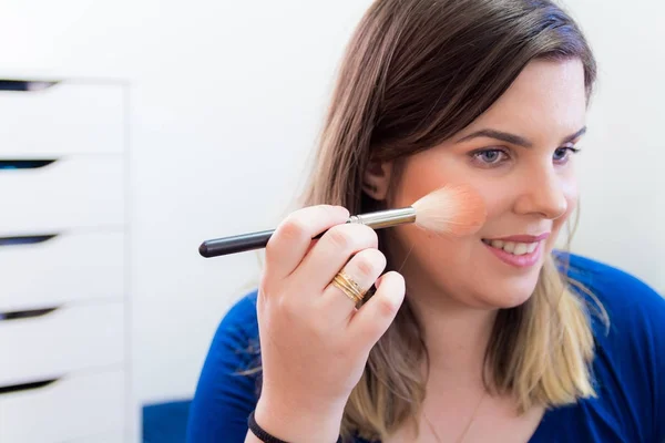 Mujer aplicando maquillaje en su dormitorio — Foto de Stock