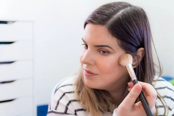 Mujer aplicando maquillaje en su dormitorio — Foto de Stock