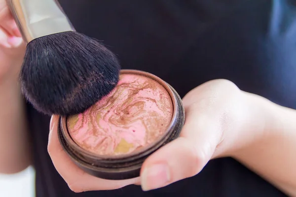 Primer plano de las manos de la mujer que sostiene bronceador de maquillaje — Foto de Stock