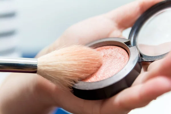 Primer plano de las manos de la mujer sosteniendo cepillo de maquillaje y caja de rubor —  Fotos de Stock