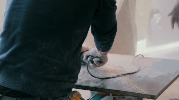 Arbeiter Schneidet Eine Fliese Mit Einem Winkelschleifer Auf Der Baustelle — Stockvideo