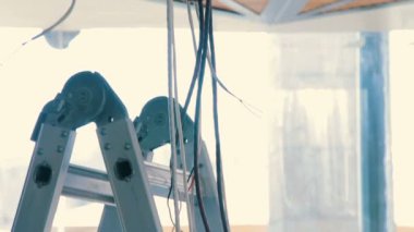 Elektrik telleri tavandan sarkan maruz. Bitirme işleri yenilenmiş kahve dükkanında. Elektrik Tesisatı yükleme.