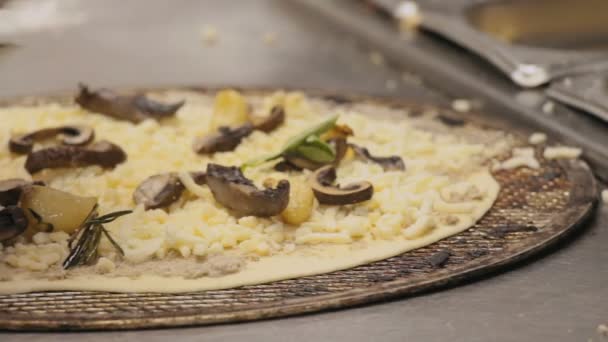 Chef bereitet eine Pizza Bianca mit Olivenaufstrich, Käse und Knoblauchstücken und Pilzen zu. — Stockvideo