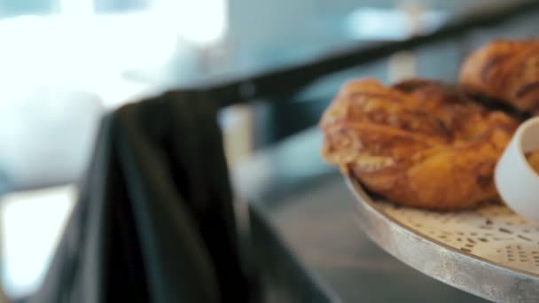 Перемещение панорамного правого снимка многих сладких хрустящих круассанов и рогалика, размещенных на подносе в кафе или булочной — стоковое видео