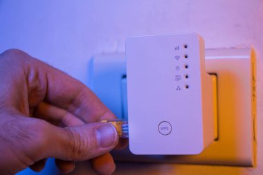 Man içinde WiFi Extender cihaza içine adam takın Ethernet kablosu 