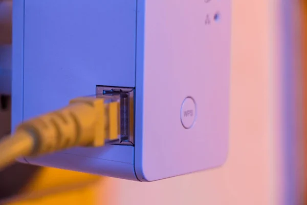 Extensor WiFi en enchufe eléctrico en la pared con cabina Ethernet — Foto de Stock