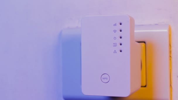 Ο άνθρωπος με το δάκτυλο στο κουμπί Wps στο Wifi repeater που είναι στην πρίζα στον τοίχο. Τη βοήθεια της συσκευής για να επεκτείνετε το ασύρματο δίκτυο στο σπίτι ή το γραφείο. — Αρχείο Βίντεο