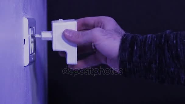 Man insert WiFi repeater into electrical socket on the wall and plug in a ethernet cable into it. The device help to extend wireless network in home or office. — Stock Video