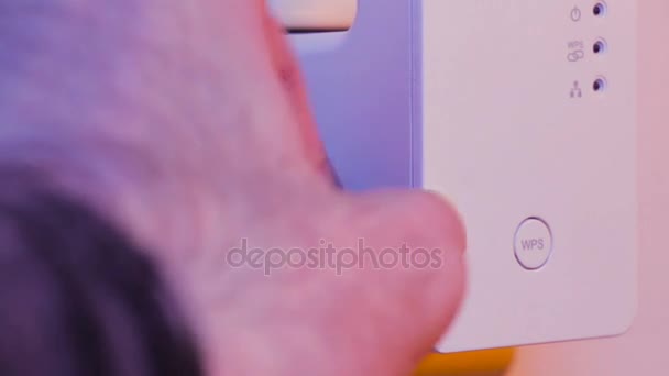 El hombre desconecta el cable Ethernet del dispositivo extensor WiFi que está en el enchufe eléctrico en la pared. El dispositivo está en modo punto de acceso que ayuda a extender la red inalámbrica en el hogar u oficina . — Vídeo de stock