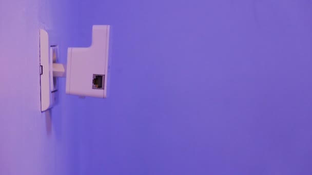 Repetidor WiFi en toma de corriente eléctrica en la pared. Dispositivo que ayuda a extender la red inalámbrica en el hogar u oficina . — Vídeo de stock