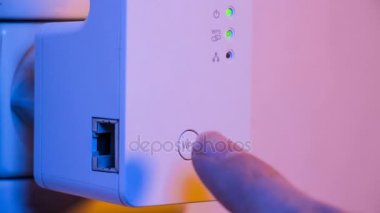 Yanıp sönen sinyal bağlantısı durumu led ışıklar Wifi Tekrarlayıcı olarak Cinemagraph. Adam closeup parmağıyla Wps butonuna basın. Duvardaki elektrik yuvasında cihazdır. Ev ya da ofis kablosuz ağ genişletmek için yardım.