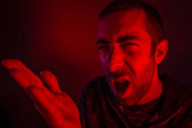 Adam yüksek sesle çığlık ve w sallayarak kızgın yüz ifadesi ile