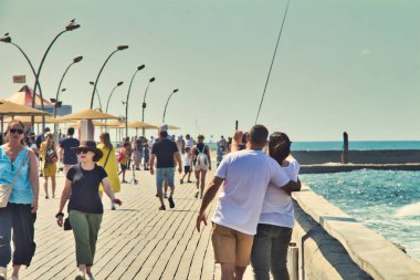 Tel Aviv, İsrail - 1 Ekim 2019: Güneşli bir yaz gününde Tel Aviv limanının ticari bölgesinde selfie çektirmek için poz veren bir çiftin arka plan görüntüsü.