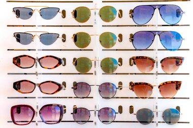 Bir sürü güneş gözlüğüyle bir optik mağazasında dikil. Ön yakın görünüm.