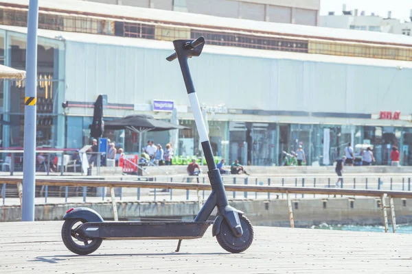 夏の晴れた日にテルアビブ港商業地区のデッキに黒い電動スクーター駐車場 コピースペースで選択的フォーカスを閉じる — ストック写真