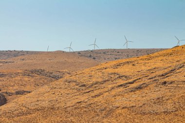 İsrail 'in Golan Tepeleri' ndeki bir dağda rüzgar türbinleri. Kuru yaz günü. Kopyalama alanı olan uzun görünüm.