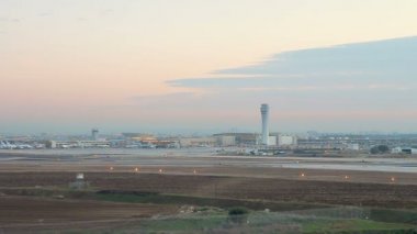 Ben Gurion Uluslararası Havaalanı 'nın öğleden sonra havadan görüntüsü. El Al Havayolları ticari uçakları ve diğerleri 1 ve 3 numaralı terminallerin yakınına park ediyor. Döndürme çekimi.