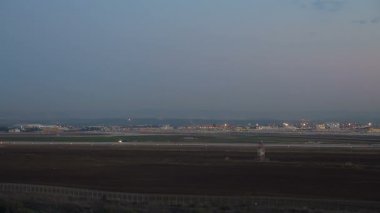 Gece Ben Gurion Uluslararası Havaalanı 'nın havadan görüntüsü. Piste bir uçak iniyor..