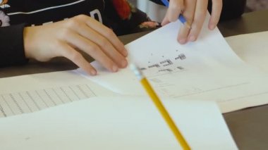 Küçük İsrailli beyaz yetenekli kız bir ilkokul sınıfında sınava giriyor. Sınavı çözmeye ve cevaplarını kağıda yazmaya çalışıyor. Elleri ve kalemi kapalı..