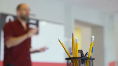 Sınıfta kurşun kalem ve kalemlerle dolu metal bir kara kutuya yaklaş. 
